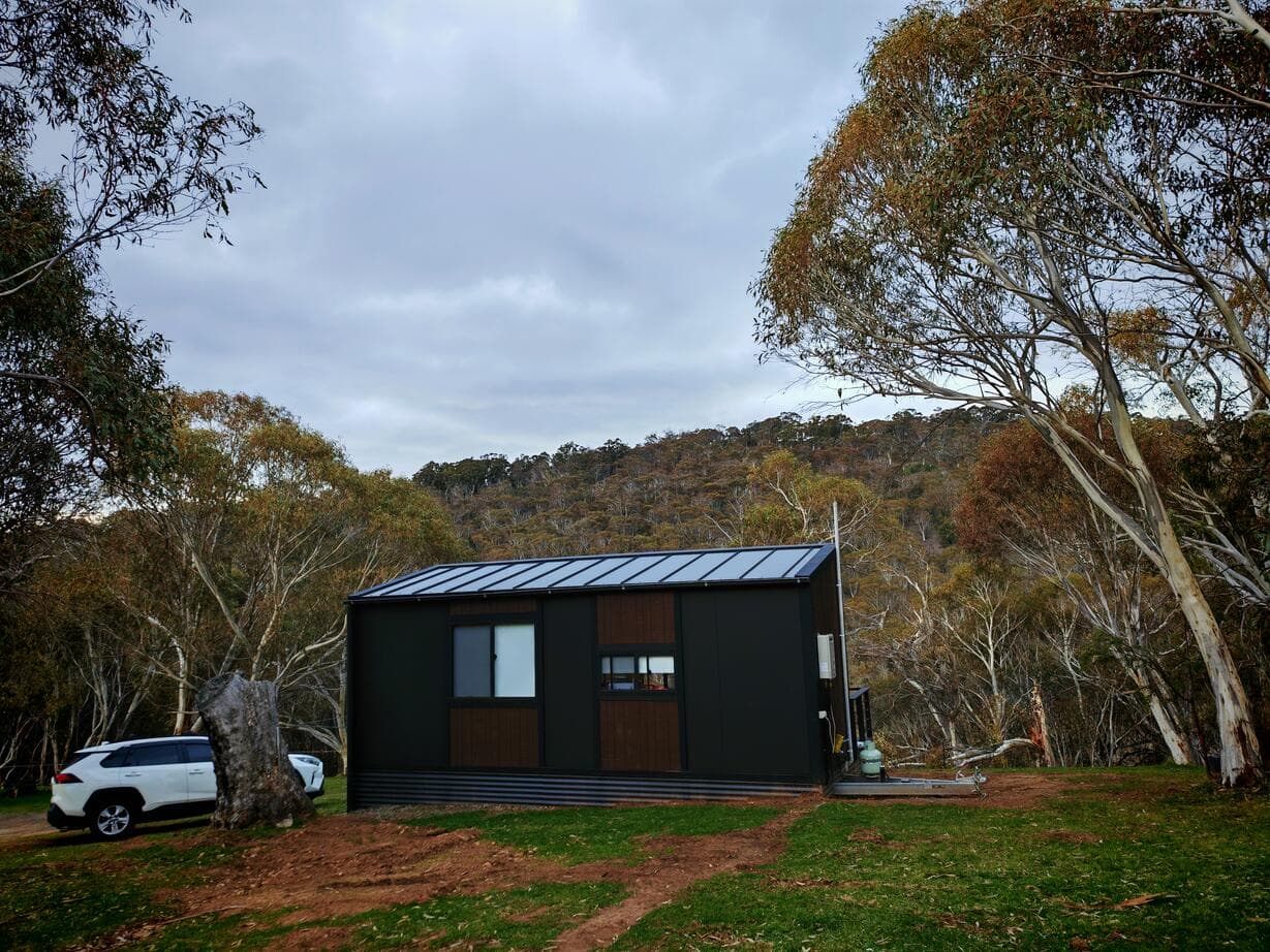 A finished black cabin on its block
